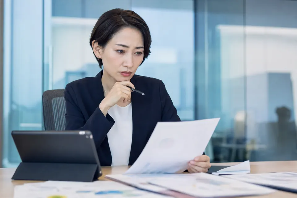 会議室で資料を分析する事業会社の経営企画担当